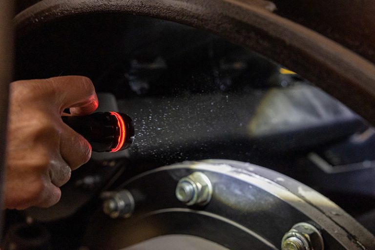 אדם מאיר בפנס על חלקי מכונה גדולה