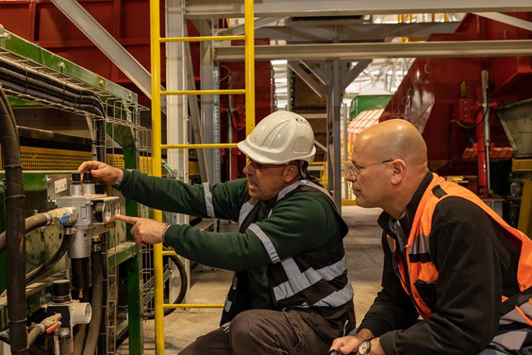 מהנדס וטכנאי בודקים ציוד במפעל